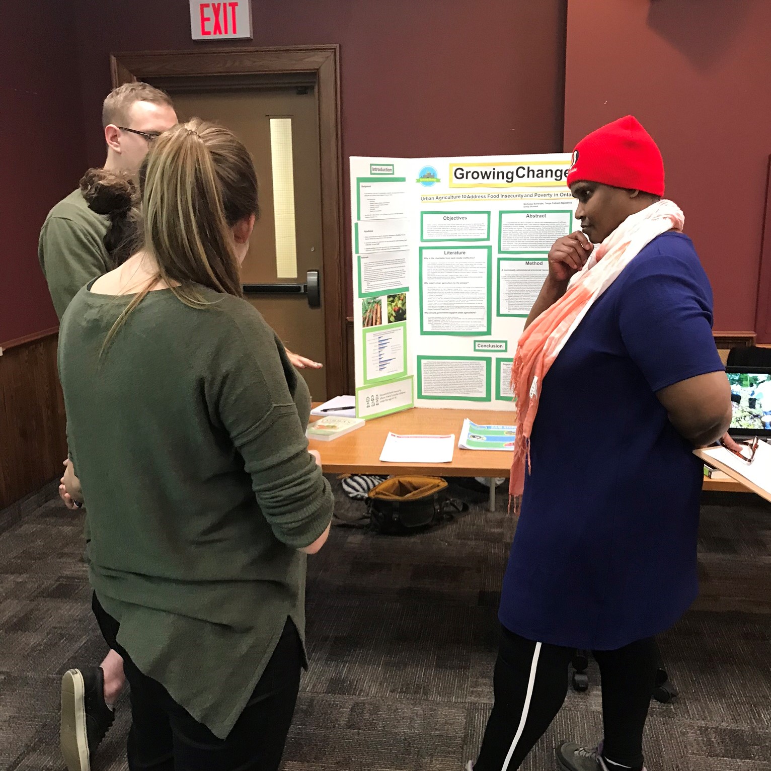 students presenting poster to symposium attendees